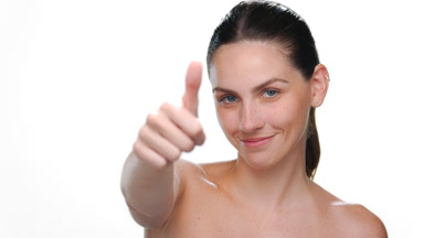 Light-skinned latina with freckles gives thumbs up on white bg