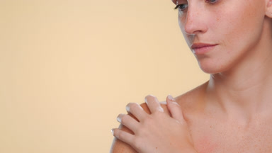 Fair-skinned freckled model highlights revitalized skin on beige