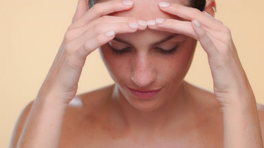 Fair-skinned freckled latina strokes forehead smooth skin