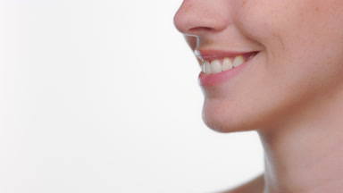 Hispanic woman with fair skin freckles smiling on white