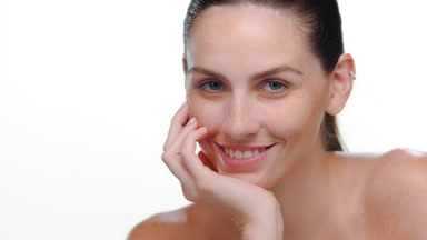 Blue-eyed fair-skinned latina smiles chin on palm white bg