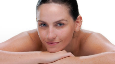 Fair-skinned latina with blue eyes rests chin on forearm