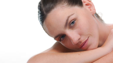 Light-skinned latina with freckles lifts head off forearm