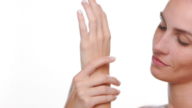 Fair-skinned hispanic with freckles caresses hands hydrated skin