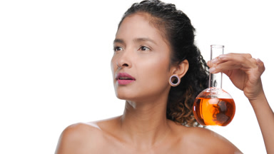 Black-haired hispanic beauty hold small flask with orange liquid