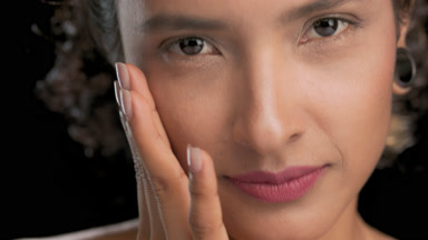 Elegant hispanic woman touches face slides from cheek to temple