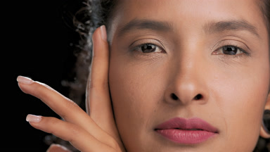 Latin beauty touches face with hand slides along jawline