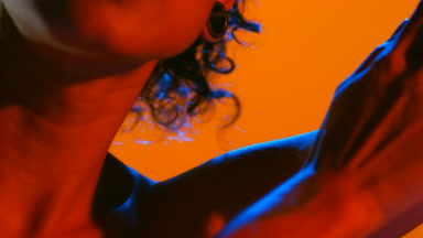 Young woman in blue and red led gently touches raised arm