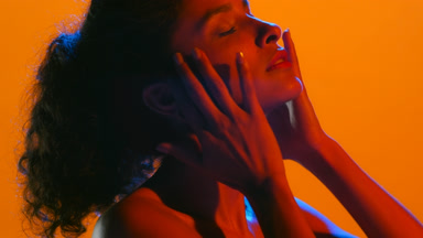 Latin woman with curly hair in red-blue led touch face and hair