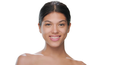 Attractive woman turns smiles showing her clear skin