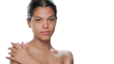 Teenage model turns smiles touches shoulder hydrated skin