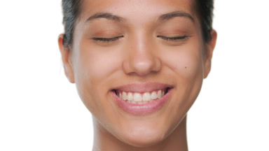 Cheerful model smiles eyes closed featuring soft skin