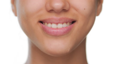 Young female's lips smile widely showing moisturized lips