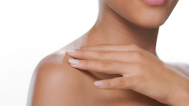 Cosmetic model strokes clavicles presenting moisturized skin