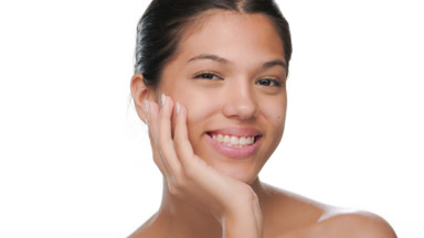 Beauty model supports chin smiles radiant skin shown