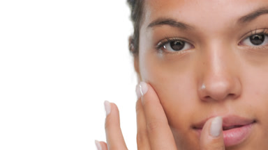 Model strokes face upwards with fingers clear skin