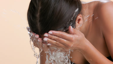 Skin care model washes face with water clear skin