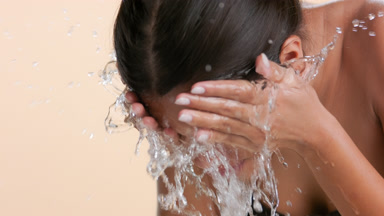Young beauty washes face with water reveals clear skin