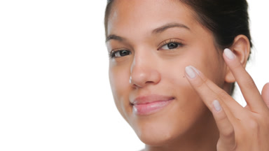 Tan beauty gently touches under eye moisturized skin