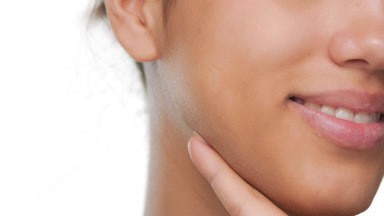Female model slides finger on jawline balanced skin