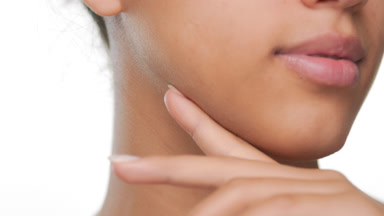 Skincare model strokes jawline shows moisturized skin