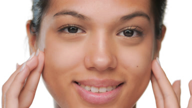 Youthful woman touches forehead cheeks showing pure skin