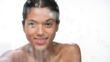 Young beauty wipes wet glass smiling brightly