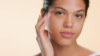 Cosmetics model touches cheek with pleasure pure skin