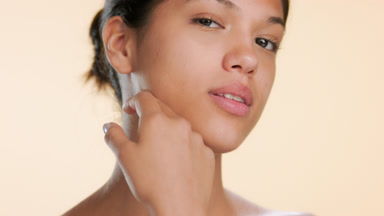 Beauty model touches jawline and face showing balanced skin