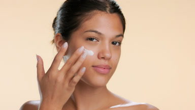 Teen model applies face cream illustrates moisturized skin
