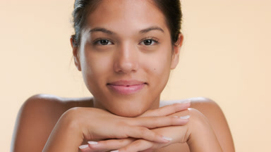 Youthful model rests chin on hands and smiles