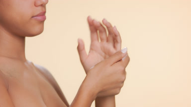 Beauty model massages hands inhales aroma of hand cream