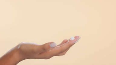 Female hand with cream drop on fingertip for skincare