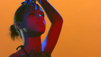 Young woman in red blue led turns face hand over head