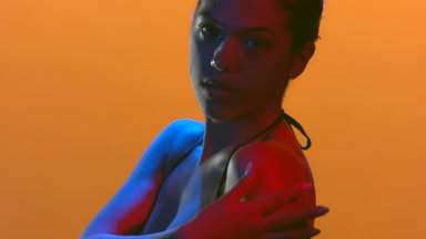 Model in blue red led strokes shoulder skin with palm