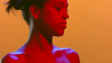 Natural beauty in red blue light turns head looks aside