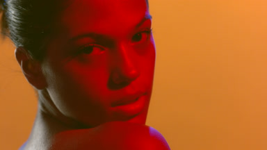 Beauty model in red led turns head looks at camera