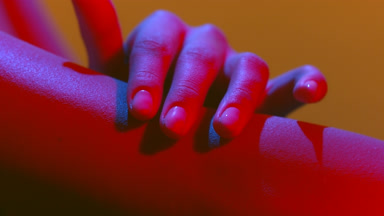 Woman's hands in red-blue led gently touch another hand