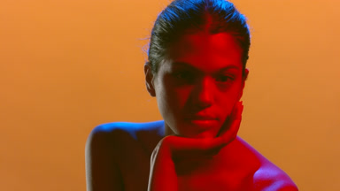 Attractive model in blue-red light supports head confident