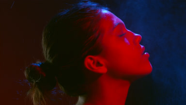 Beauty in red light sprays fragrance and inhales aroma