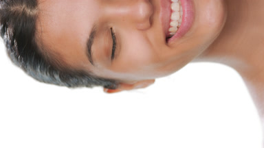 Skincare model smiles eyes closed showing clear skin