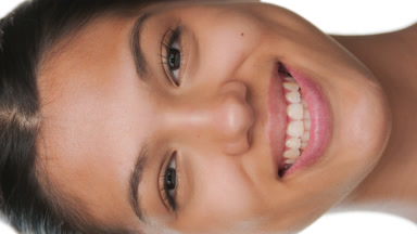 Youthful woman smiles for camera presenting pure skin