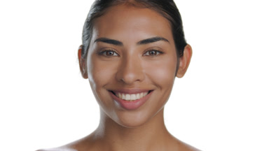 Young brunette woman smiling, showcasing her smooth, soft skin