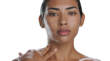 Mid-brown-skinned woman strokes nape, exhibits moisturized skin