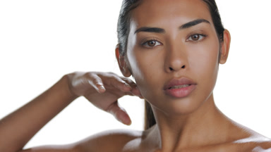 Tan Hispanic model stroking jawline, introducing soothed skin