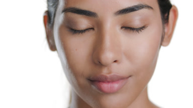 Latin woman with light brown skin smiles, shows balanced skin