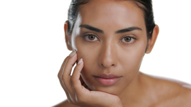 Youthful Latin model props chin with palm, displays matte skin