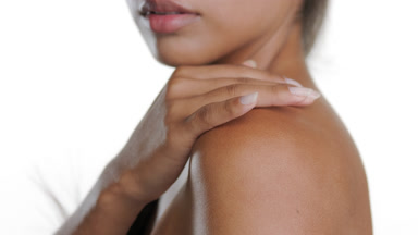 Brunette Hispanic woman strokes skin, promoting moisturized body