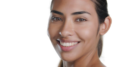 Young brunette woman looks over shoulder, exposing fresh skin