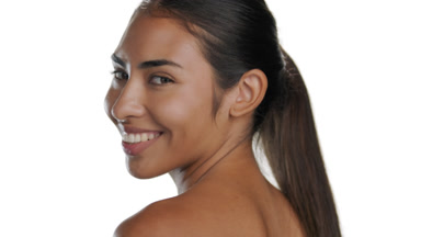 Warm-toned Latin woman smiles, turns away, pure skin focus